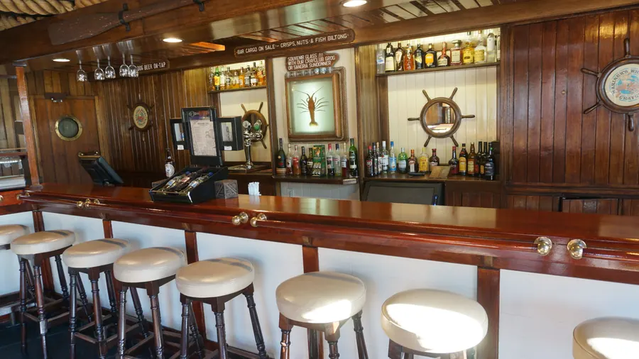 The Crayclub bar, wood-panelled with ship’s wheels and brass