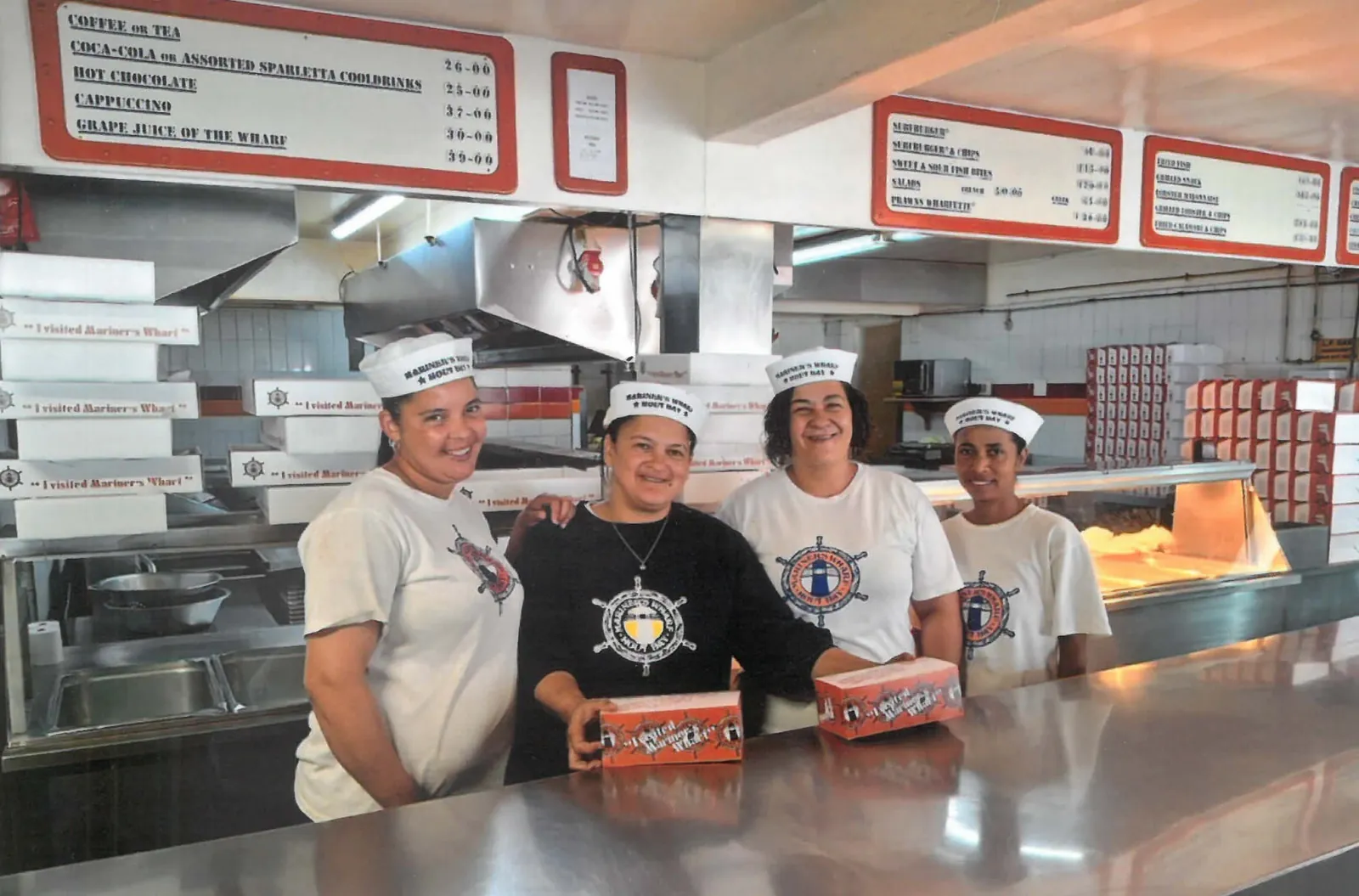 The Wharfette Bistro crew holding fish and chips boxes at the counter